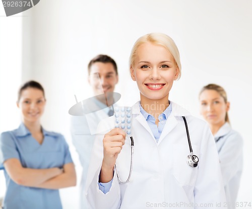 Image of smiling female doctor with pills