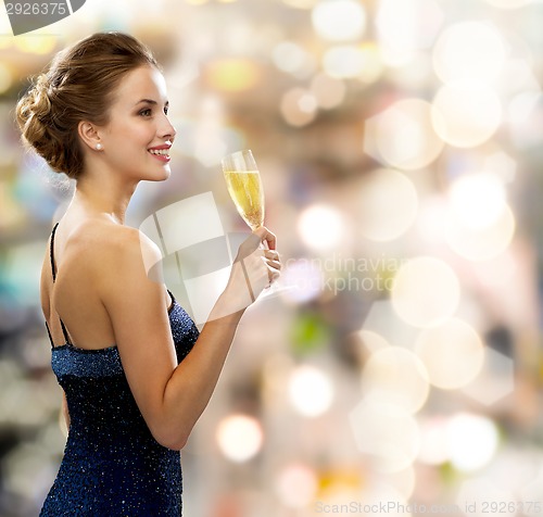Image of smiling woman holding glass of sparkling wine