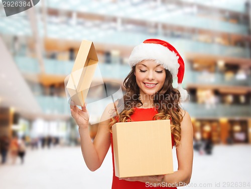 Image of smiling woman in santa helper hat with gift box