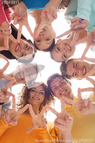 Image of group of smiling teenagers showing victory sign