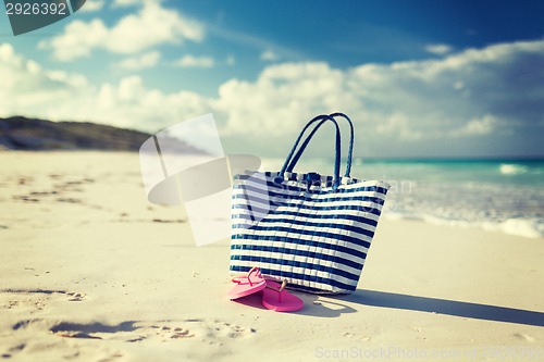 Image of close up of beach bag and slippers at seaside