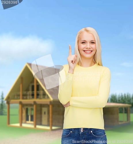 Image of smiling woman pointing her finger up