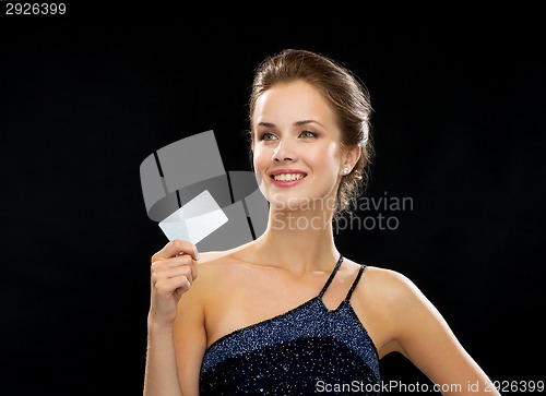 Image of smiling woman in evening dress holding credit card