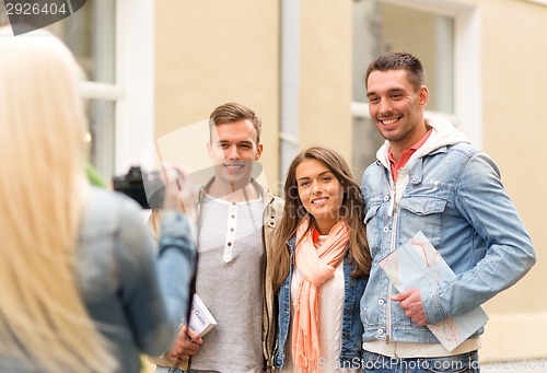 Image of group of smiling friends taking photo outdoors