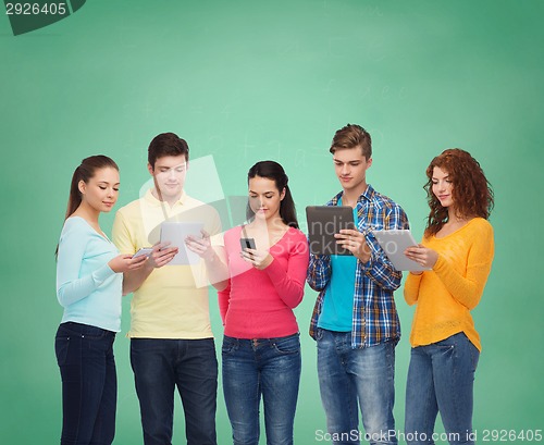 Image of group of teenagers with smartphones and tablet pc