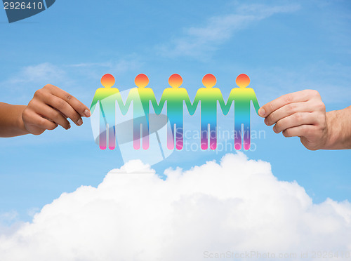 Image of close up of hands holding paper chain gay people