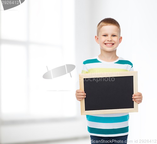 Image of smiling little boy holding blank black chalkboard