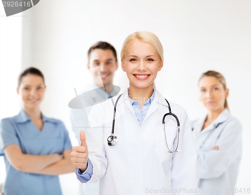 Image of smiling female doctor showing thumbs up