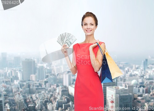 Image of smiling woman in red dress with shopping bags