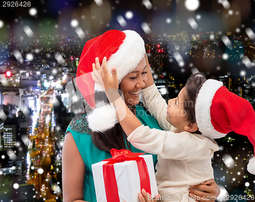 Image of happy mother and child girl with gift box