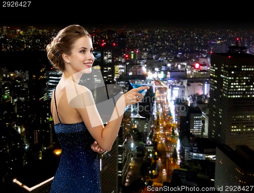 Image of smiling woman holding cocktail