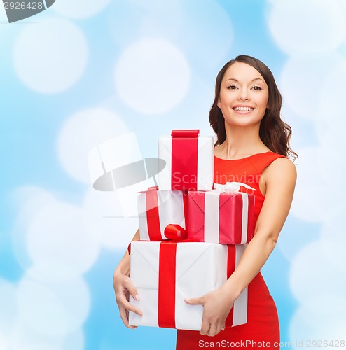 Image of smiling woman in red dress with gift boxes