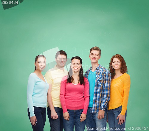 Image of group of smiling teenagers over green board