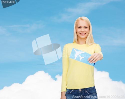 Image of smiling young woman with airplane ticket