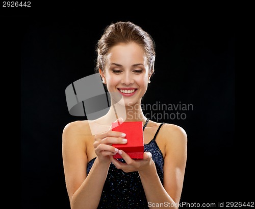 Image of smiling woman holding red gift box