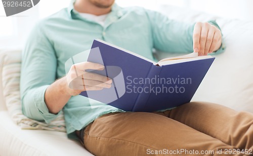 Image of close up of man reading book at home