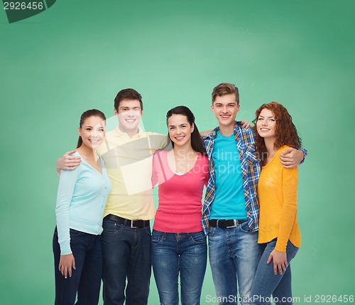 Image of group of smiling teenagers over green board