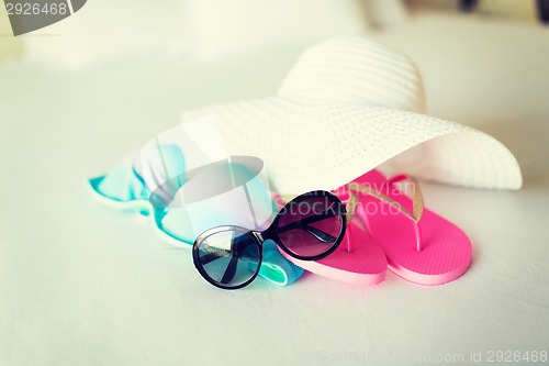 Image of bikini top, hat, flip-flop and sunglasses
