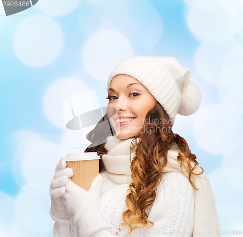 Image of smiling young woman in winter clothes with cup