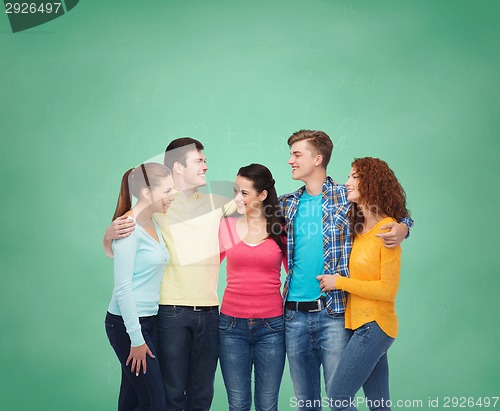Image of group of smiling teenagers over green board