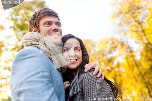 Image of smiling couple hugging in autumn park