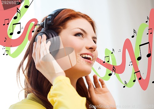 Image of smiling young girl in headphones at home