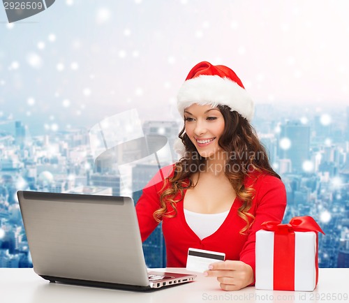 Image of smiling woman with credit card and laptop