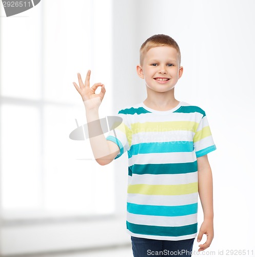 Image of little boy in casual clothes making ok gesture
