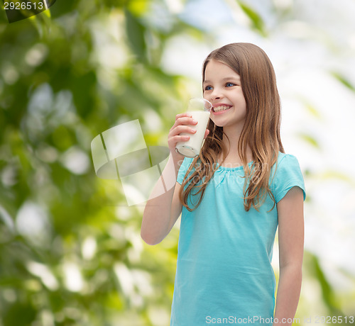 Image of smiling little girl drinking milk out of glass