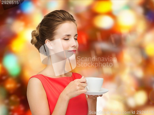 Image of smiling woman in red dress with cup of coffee