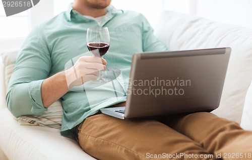 Image of close up of man with laptop and wine glass