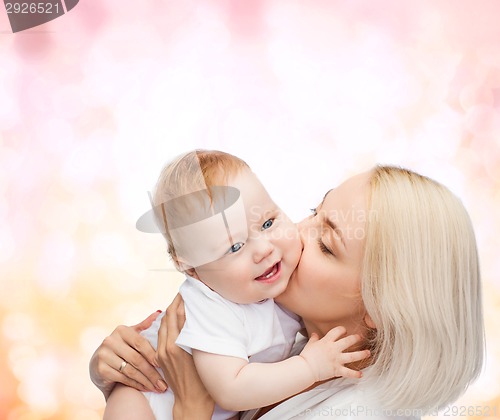 Image of happy mother kissing smiling baby