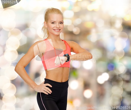 Image of smiling woman with heart rate monitor on hand