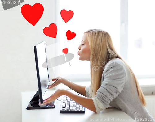 Image of woman sending kisses with computer monitor