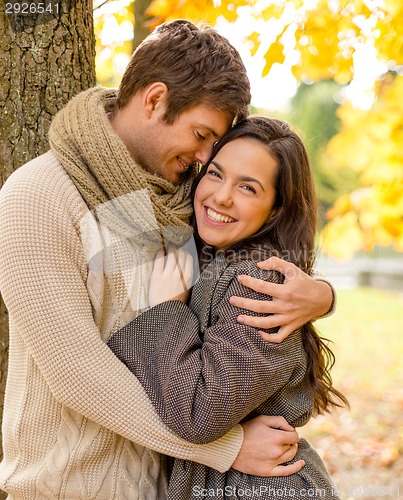 Image of smiling couple hugging in autumn park