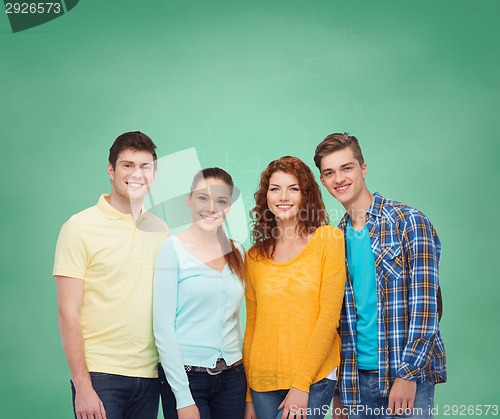 Image of group of smiling teenagers over green board