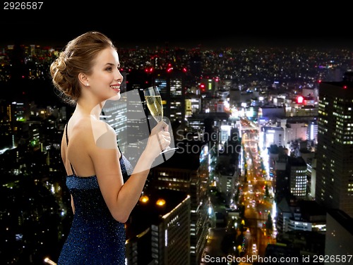 Image of smiling woman holding glass of sparkling wine