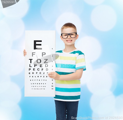 Image of smiling boy in eyeglasses with white blank board