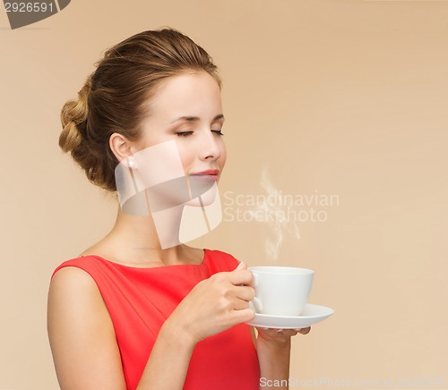 Image of smiling woman in red dress with cup of coffee