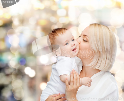 Image of happy mother kissing smiling baby