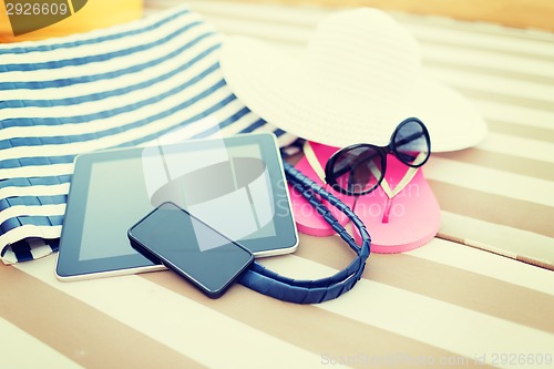 Image of close up of tablet pc and smartphone on beach