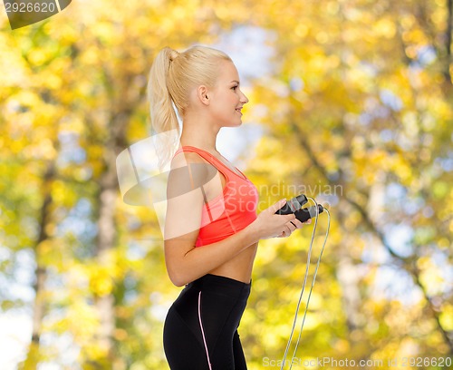 Image of smiling sporty woman with skipping rope