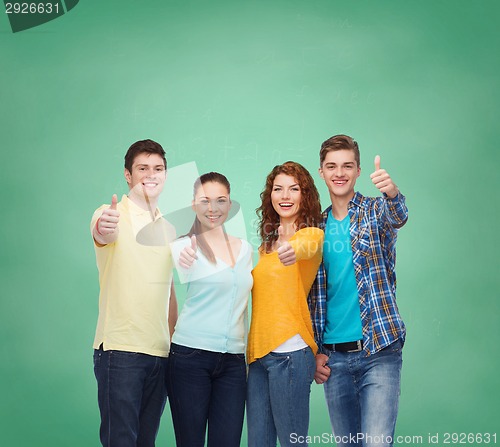 Image of group of smiling teenagers over green board