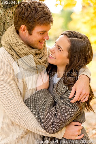 Image of smiling couple hugging in autumn park