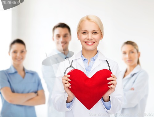 Image of smiling female doctor with heart and stethoscope