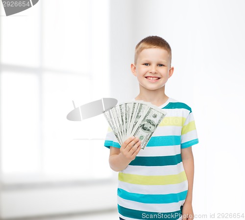 Image of smiling boy holding dollar cash money in his hand