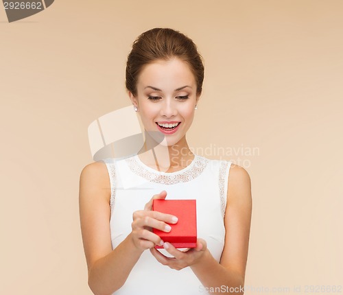 Image of smiling woman holding red gift box