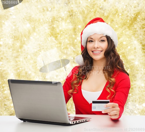 Image of smiling woman with credit card and laptop