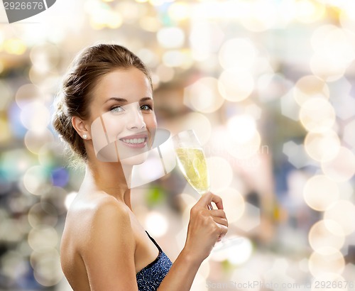 Image of smiling woman holding glass of sparkling wine