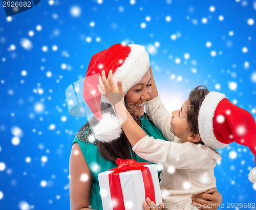 Image of happy mother and child girl with gift box